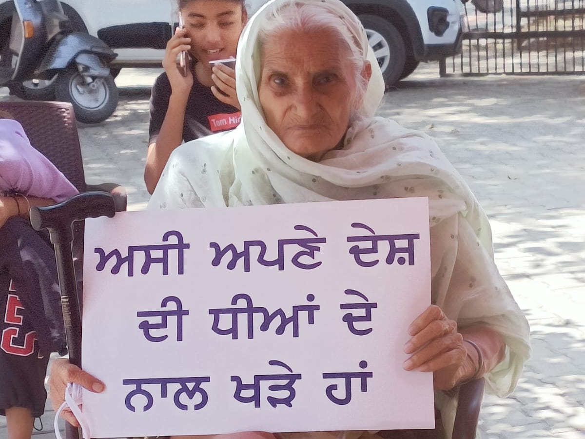 पहलवानों के समर्थन में धरने पर बैठी बुजुर्ग महिला।