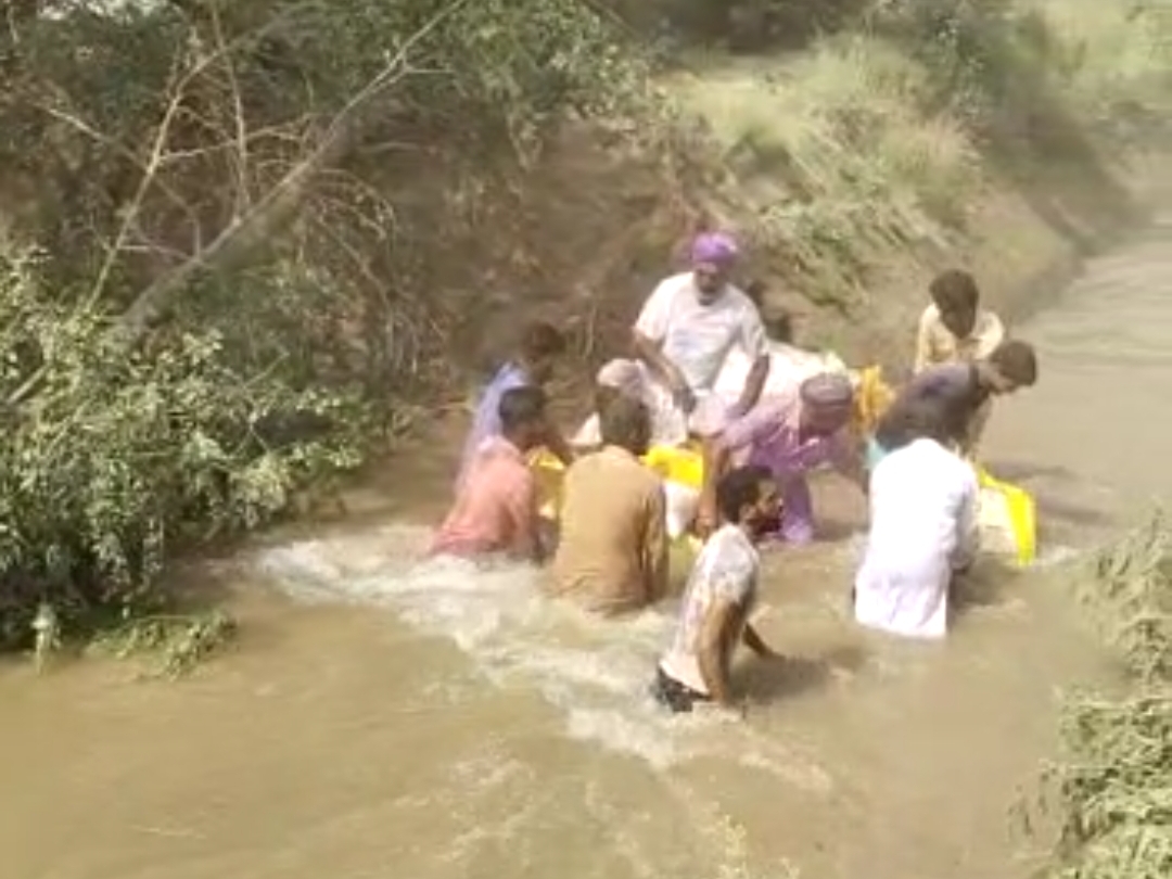 कटाव को बांधने का प्रयास करते किसान।