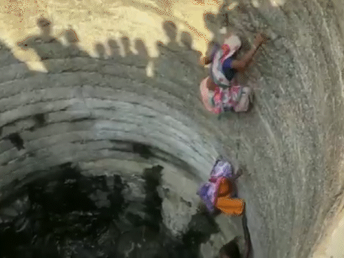कुएं में नीचे उतरकर महिलाएं तलहटी में मौजूद पानी को बर्तनों में जमा करती हैं, जिन्हें ऊपर खड़ी महिलाएं खींच लेती हैं। - Dainik Bhaskar