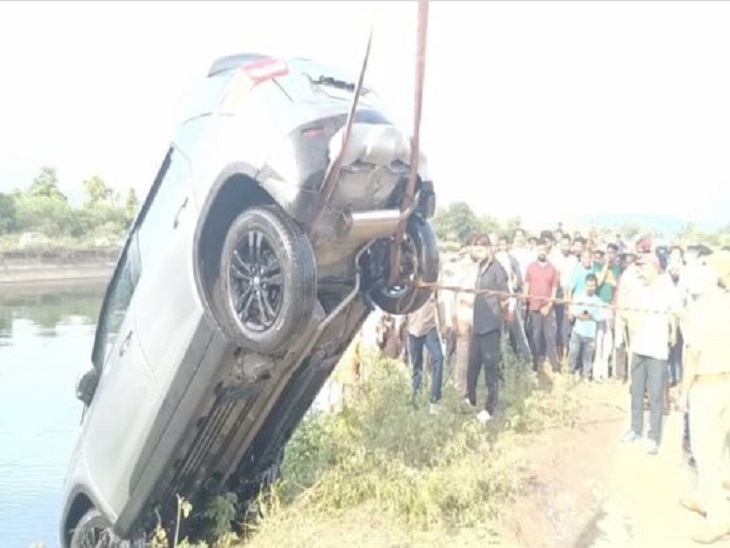 क्रेन की मदद से नहर से निकाली जा रही कार और मौके पर जमा भीड़