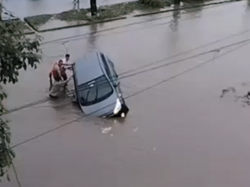 राजकोट में सड़क के बीच अचानक गड्ढा हो जाने से एक कार फंस गई।