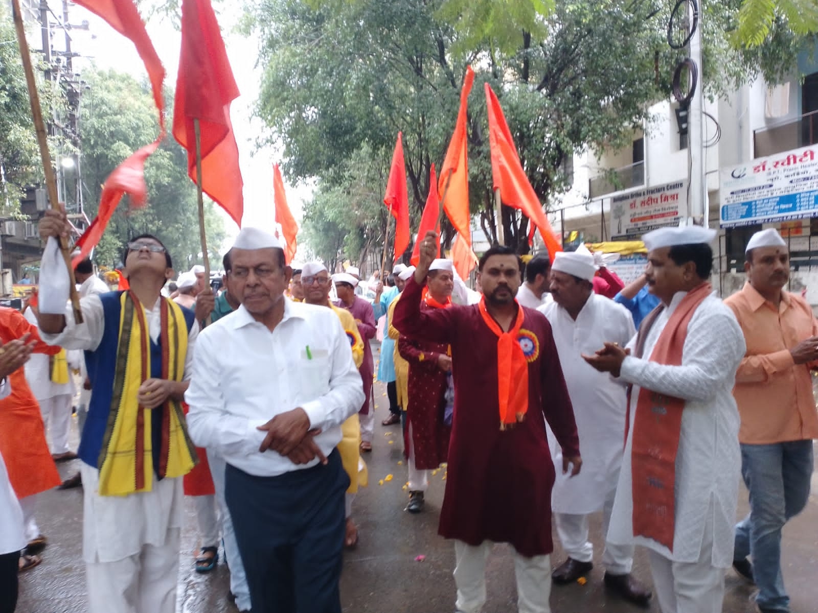 यात्रा में भगवा ध्वज लेकर शामिल हुए भक्त।