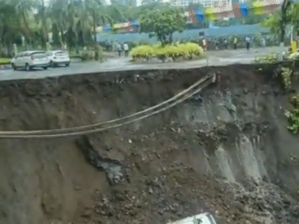 मुंबई में बारिश के चलते सड़क का बड़ा हिस्सा धंस गया, जिसमें कई गाड़ियां गिर पड़ीं।