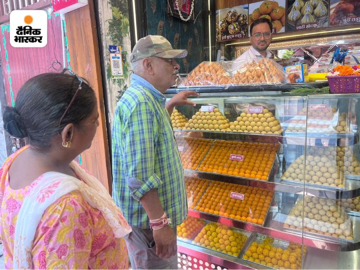 खजराना गणेश मंदिर स्थित मिठाई की दुकान में लड्डू खरीदते दिखे अनिल मेहता और पत्नी गीता।