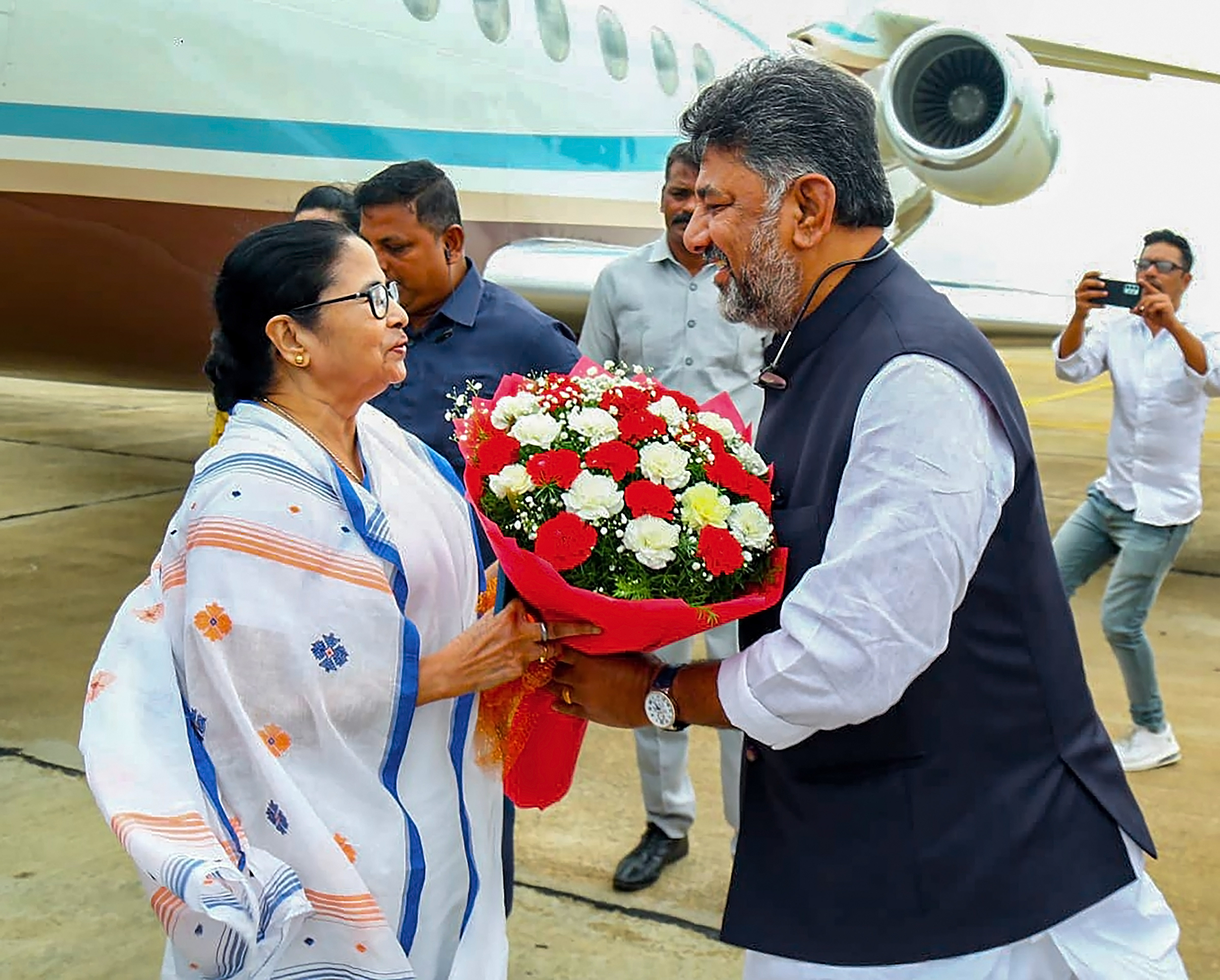 बेंगलुरु पहुंची ममता बनर्जी का स्वागत करते कर्नाटक के डिप्टी CM डीके शिवकुमार।