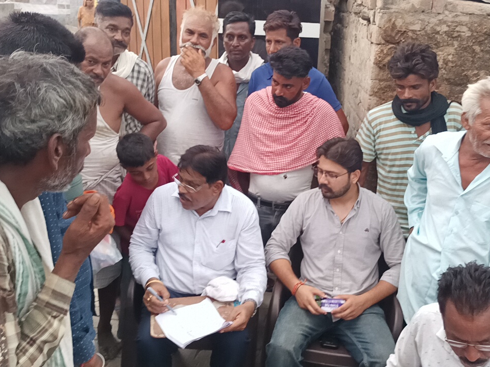 राशन वितरण करने के दौरान ग्रामीणों से साइन कराते अधिकारी।