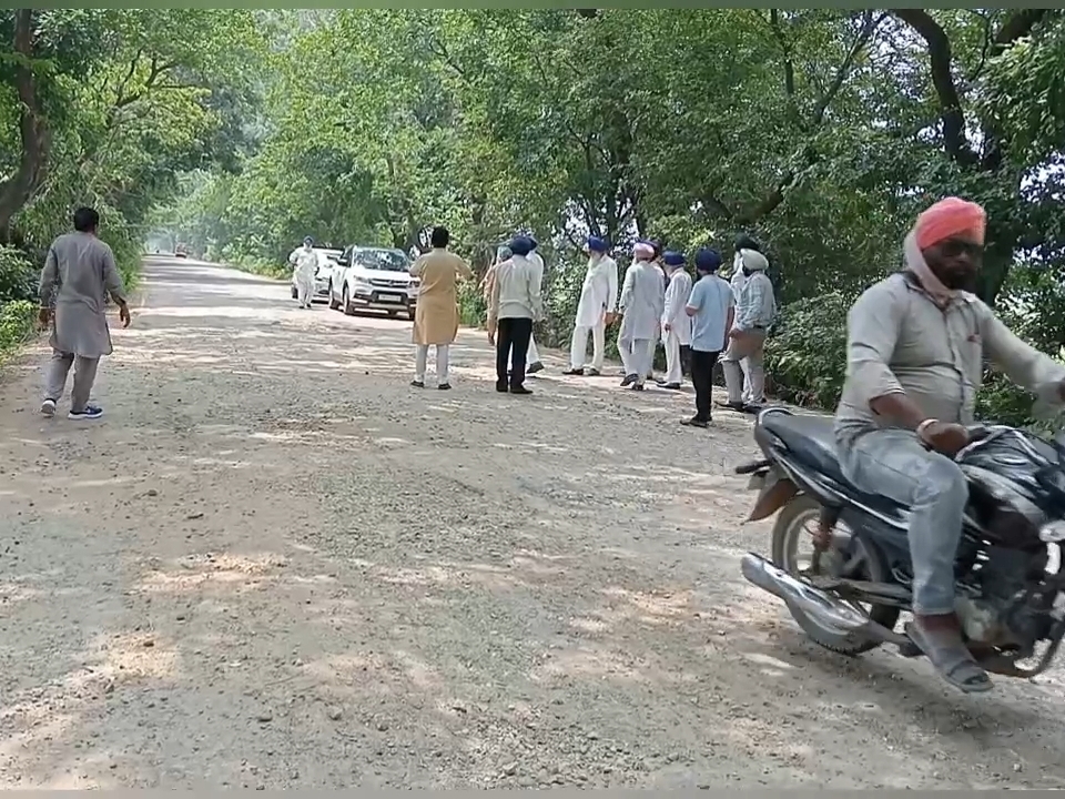 रोड की हालत दिखाते ग्रामीण।