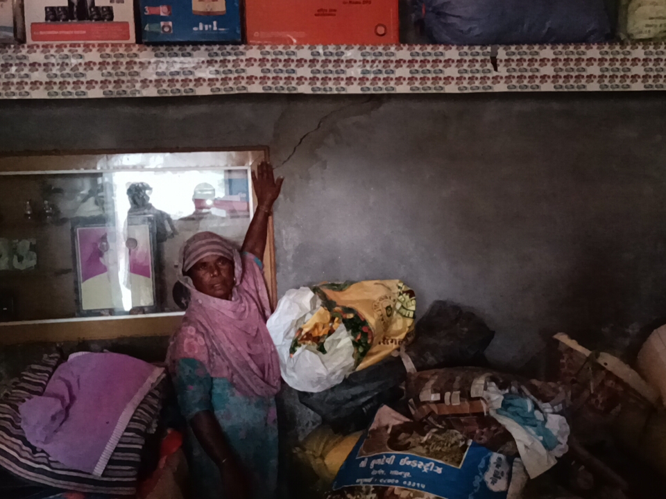 मकान में आई दरार दिखाती विधवा महिला।