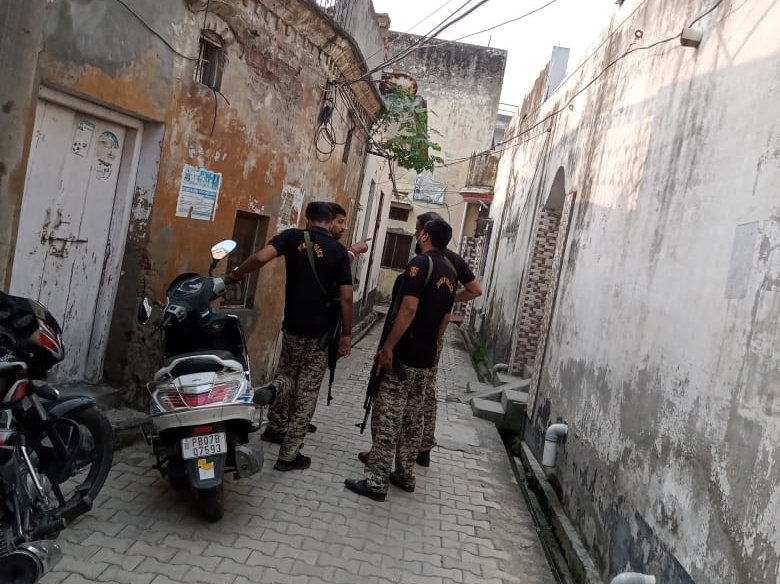 अध्यापक के घर के बाहर खड़े NIA जवान।