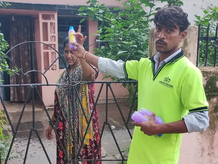 लार्वा खत्म करने की दवा लोगों को देते निगम कर्मी।