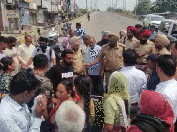 जालंधर के रामामंडी में प्रदर्शनकारियों से पुलिस अधिकारियों की मौजूदगी में बहस करते लोग