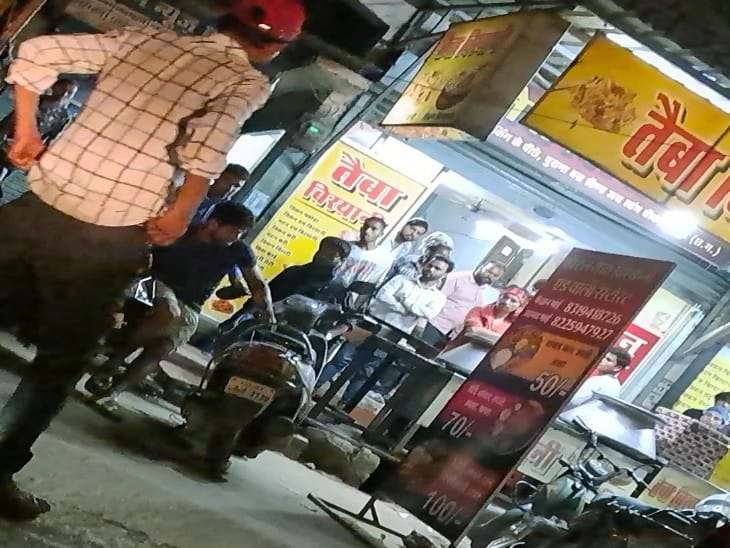 स्कूटर के पास घायल युवक घुटने मोड़कर खड़ा था, भीड़ बेबसी से देखती रही।