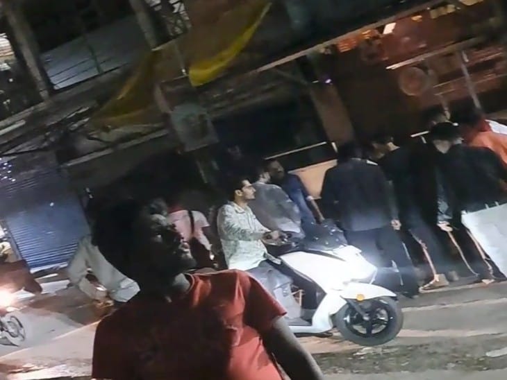 सड़क पर गिरे घायल को देखने लोग जमा हुए।