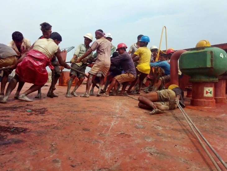 शिपब्रेकिंग यार्ड में मजदूर बिना सेफ्टी गियर के काम करते दिख रहे हैं।