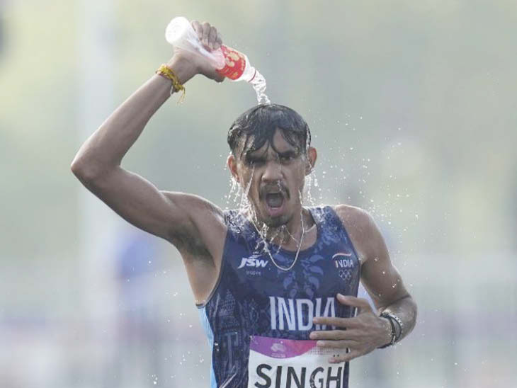 19वें एशियाई खेलों में पुरुषों की 20 किमी रेस वॉक फ़ाइनल के दौरान भारत के विकास सिंह खुद को पानी से ठंडा करते हुए।