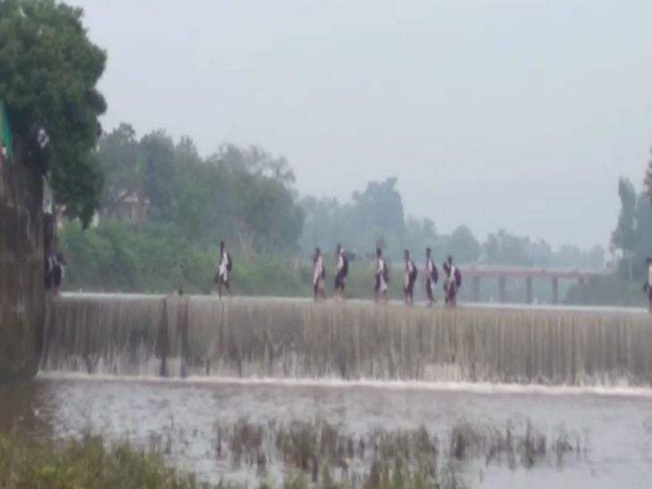 नदी में खतरे से खेल रहीं स्कूली बच्चियां:जान हथेली पर रख पार कर रहे एनिकट, बगल में पुलिस चौकी, सुरक्षा के इंतजाम नहीं 2 उफनते एनिकट को स्कूली बच्चियां पार कर रहीं हैं।