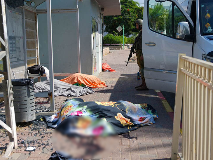 इजराइल के अश्कलोन में एक स्टोर के बाहर हमास के हमलों में मारे गए लोगों के शव नजर आए।