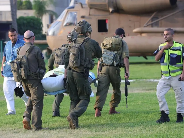 हमले में घायल एक व्यक्ति को अस्पताल ले जाते इजराइली सैनिक।