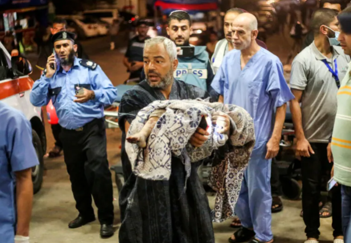 तस्वीर गाजा के सबसे ज्यादा आबादी वाले इलाके खान यूनिस की है, जहां एक शख्स इजराइल हमले में घायल एक बच्चे को लेकर अस्पताल पहुंचा है।