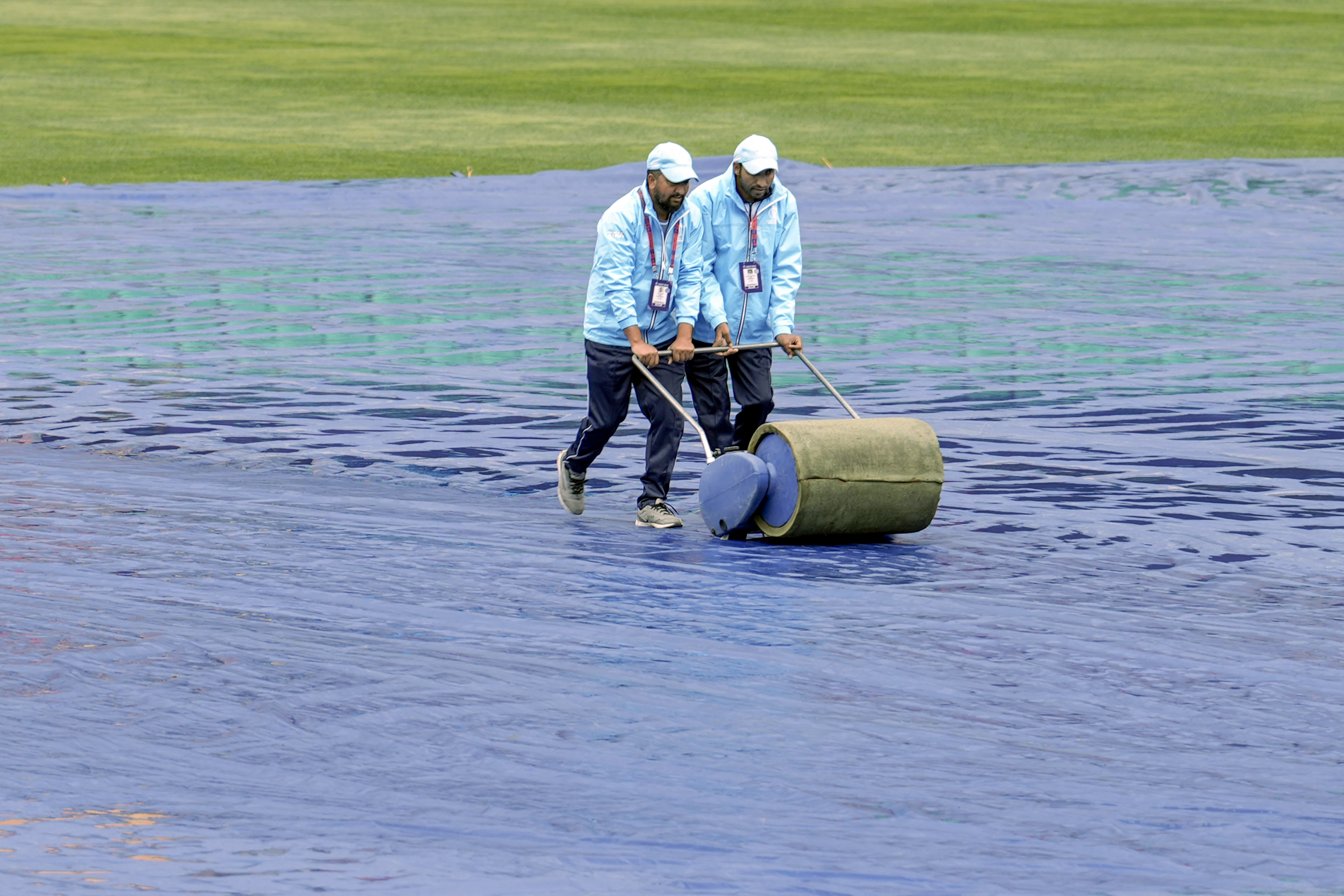 बारिश रुकने के बाद मैदान तैयार करते धर्मशाला ग्राउंड क्रू।