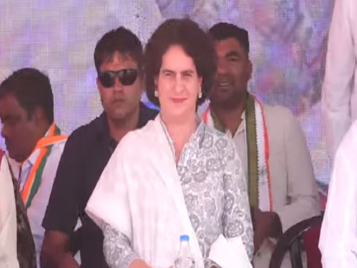 मंच पर बैठी हुई खुश नजर आतीं प्रियंका गांधी।