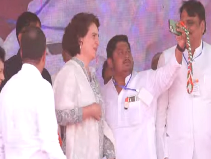 मंच पर प्रियंका गांधी के साथ सेल्फी लेते हुए कांग्रेस कार्यकर्ता।