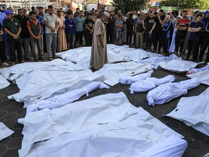 गाजा के अस्पताल के बाहर इजराइली हमले में मारे गए फिलिस्तीनियों के शव रखे गए।