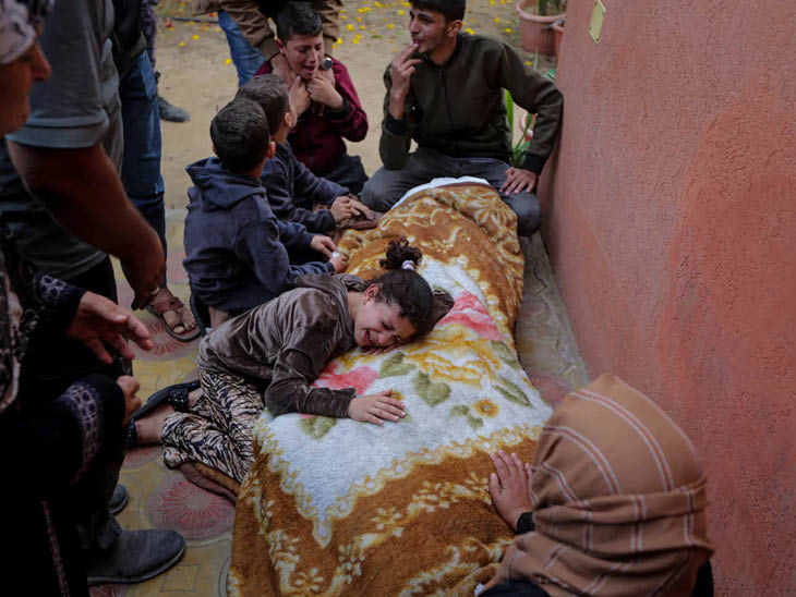 गाजा में अपनों को खोने के बाद शव से लिपटकर रोती बच्ची।