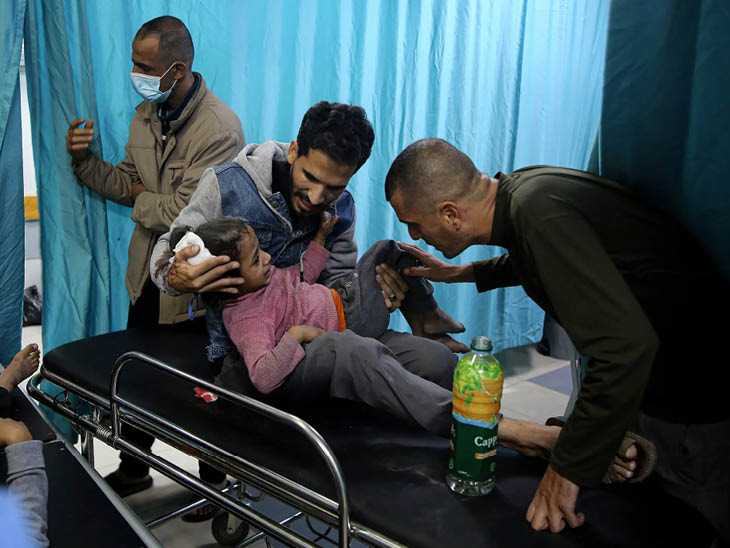 गाजा के अल-शिफा अस्पताल में अपनी बच्ची के इलाज के लिए पहुंचा फिलिस्तीनी।