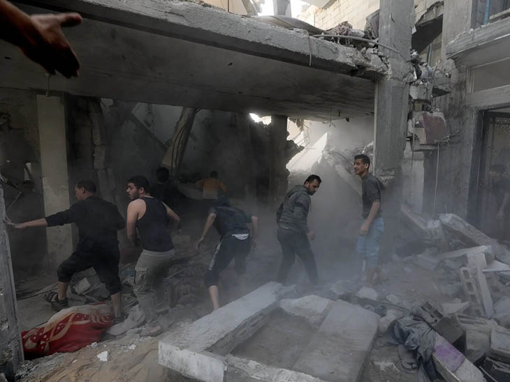 फिलिस्तीनी गाजा के खान यूनिस में एक घर के मलबे के बीच शवों और जीवित बचे लोगों को ढूंढते दिखे।