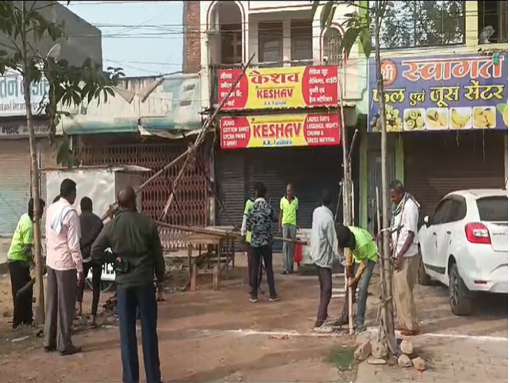 मार्किंग के बाहर लगी दुकानों को हटाते हुए निगम की टीम।