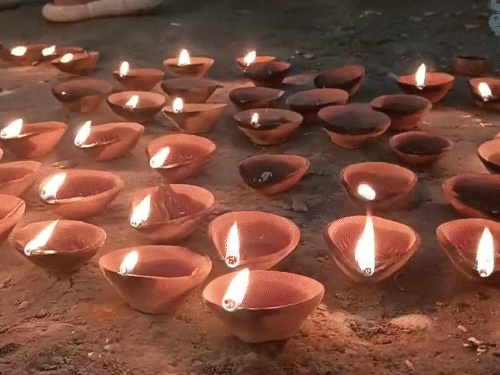 काशी के घाटों और सीढ़ियों पर दीये जलाते पर्यटक और भक्त।
