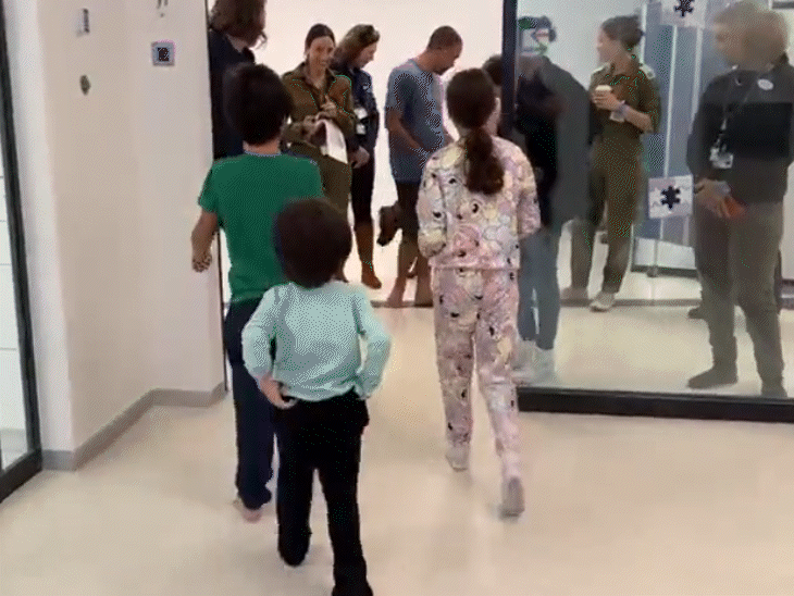 युवल, ओफ्री और उरीया ब्रोडेट्ज 51 दिनों की कैद के बाद अपने पालतू कुत्ते से मिले।