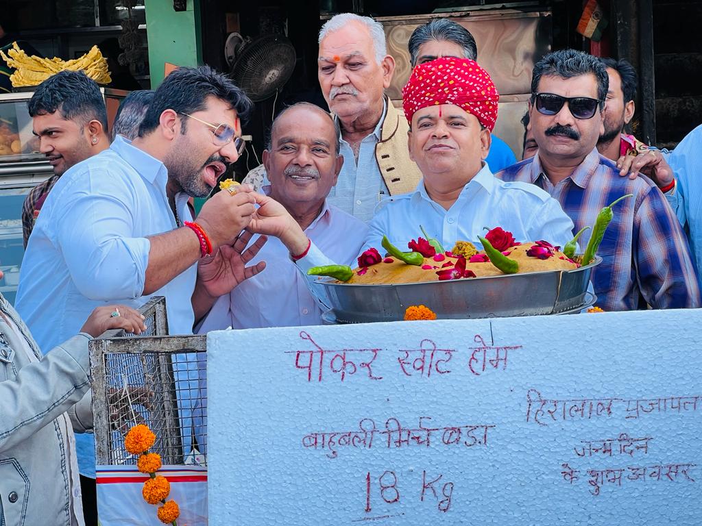 मिर्ची बड़ा काटने के बाद लोगों को अपने हाथ से खिलाते हुए हीरालाल समाज सेवी।