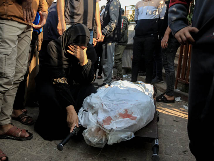 खान यूनिस में अपने परिजन के शव के पास रो रही एक महिला।