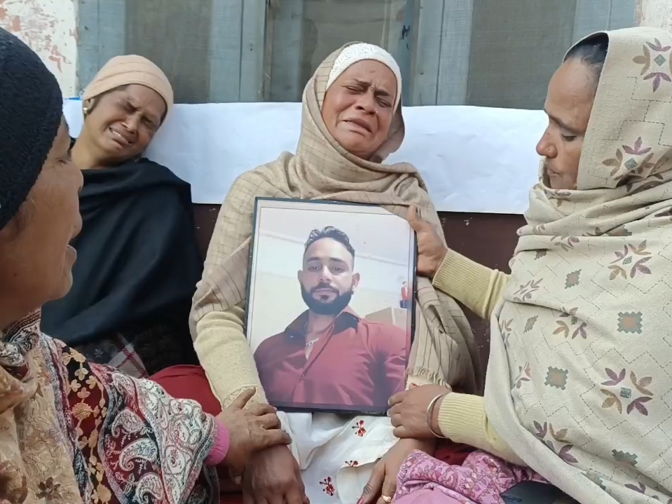 युवक की फोटो हाथ में लेकर विलाप करते परिजन। - Dainik Bhaskar
