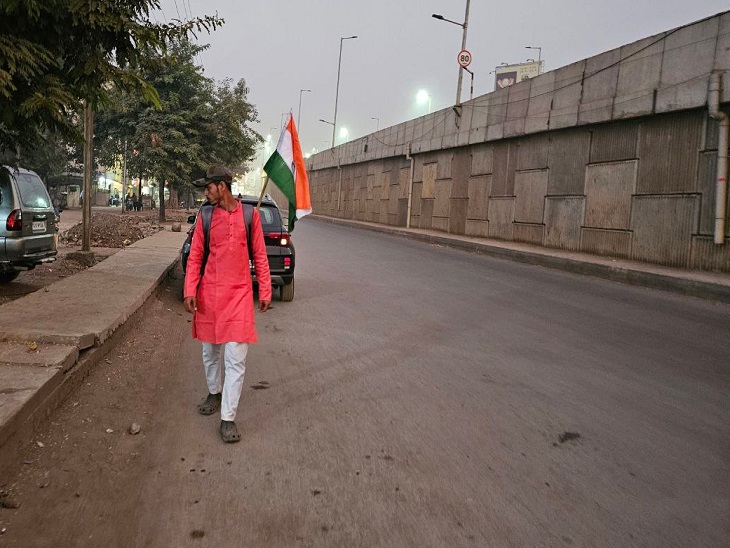 बैग में तिरंगा लगाकर उल्टे कदम एनएच पर चलता हुआ मेहुल।