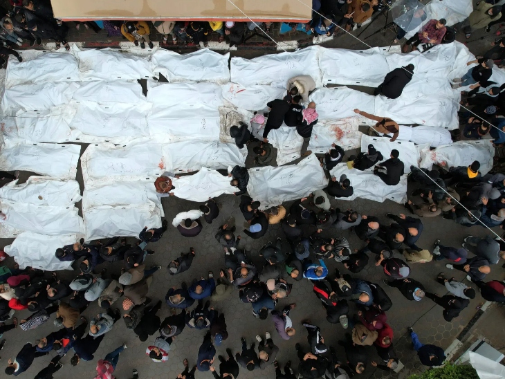 अल-मघाजी कैंप पर हुए इजराइली हमले के बाद मारे गए लोगों के शवों को एक साथ रखा गया।