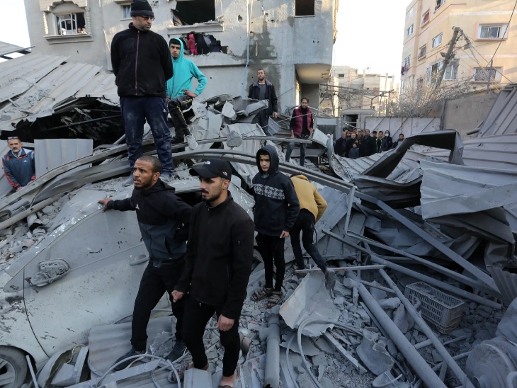 गाजा में इजराइली बमबारी के बाद मलबे में दबे परिजनों को ढूंढते लोग।