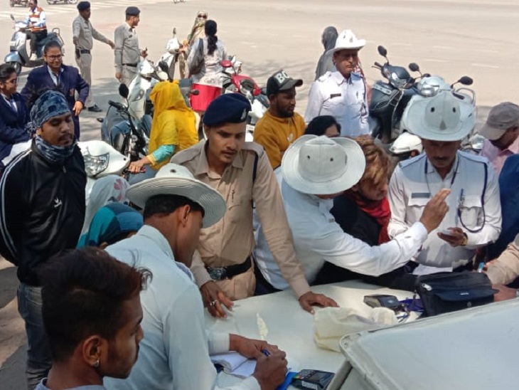 नियम तोड़ने वाले वाहन चालकों पर कार्रवाई करते हुए ट्रैफिक पुलिस के अधिकारी-कर्मचारी।
