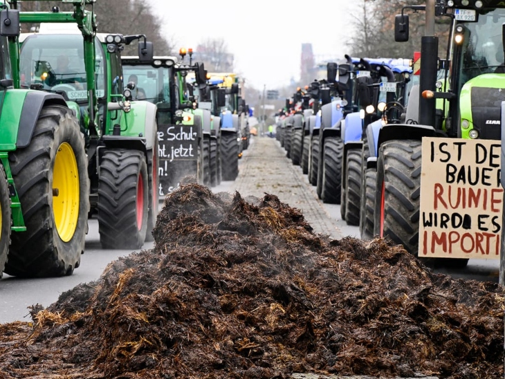 म्यूनिख में किसानों ने कृषि सब्सिडी में कटौती के सरकार के फैसले का विरोध करते हुए सड़क पर खाद फैला दी।