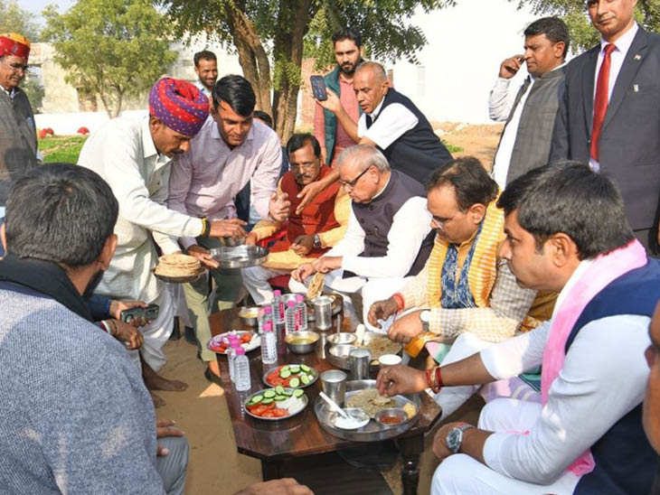 दूदू के एक गांव में बीजेपी कार्यकर्ता के खेत में भोजन करते हुए मुख्यमंत्री भजनलाल शर्मा।