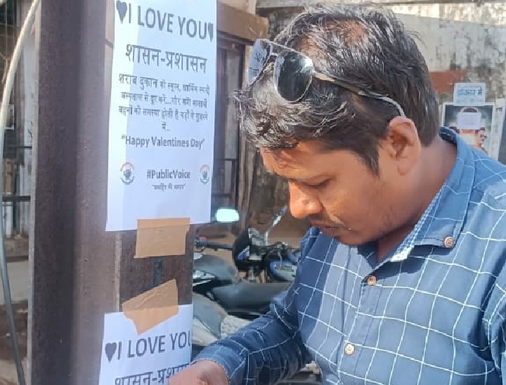 पर्चा लगाते पब्लिक वॉइस संगठन के सदस्य।