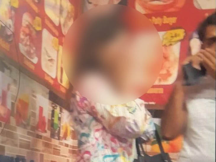 तस्वीर उस महिला की है जिसे भीड़ ने घेरा। उसके कपड़ों पर अरबी शब्द दिख रहे हैं।