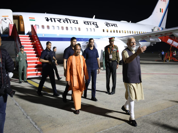 एयरपोर्ट के रनवे पर विमान उतरने के बाद कार में सवार होने के लिए जाते PM मोदी और CM योगी आदित्यनाथ।