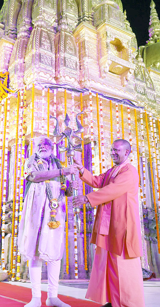 श्रीकाशी विश्वनाथ मंदिर में पीएम को त्रिशूल सौंपते योगी आदित्यनाथ।