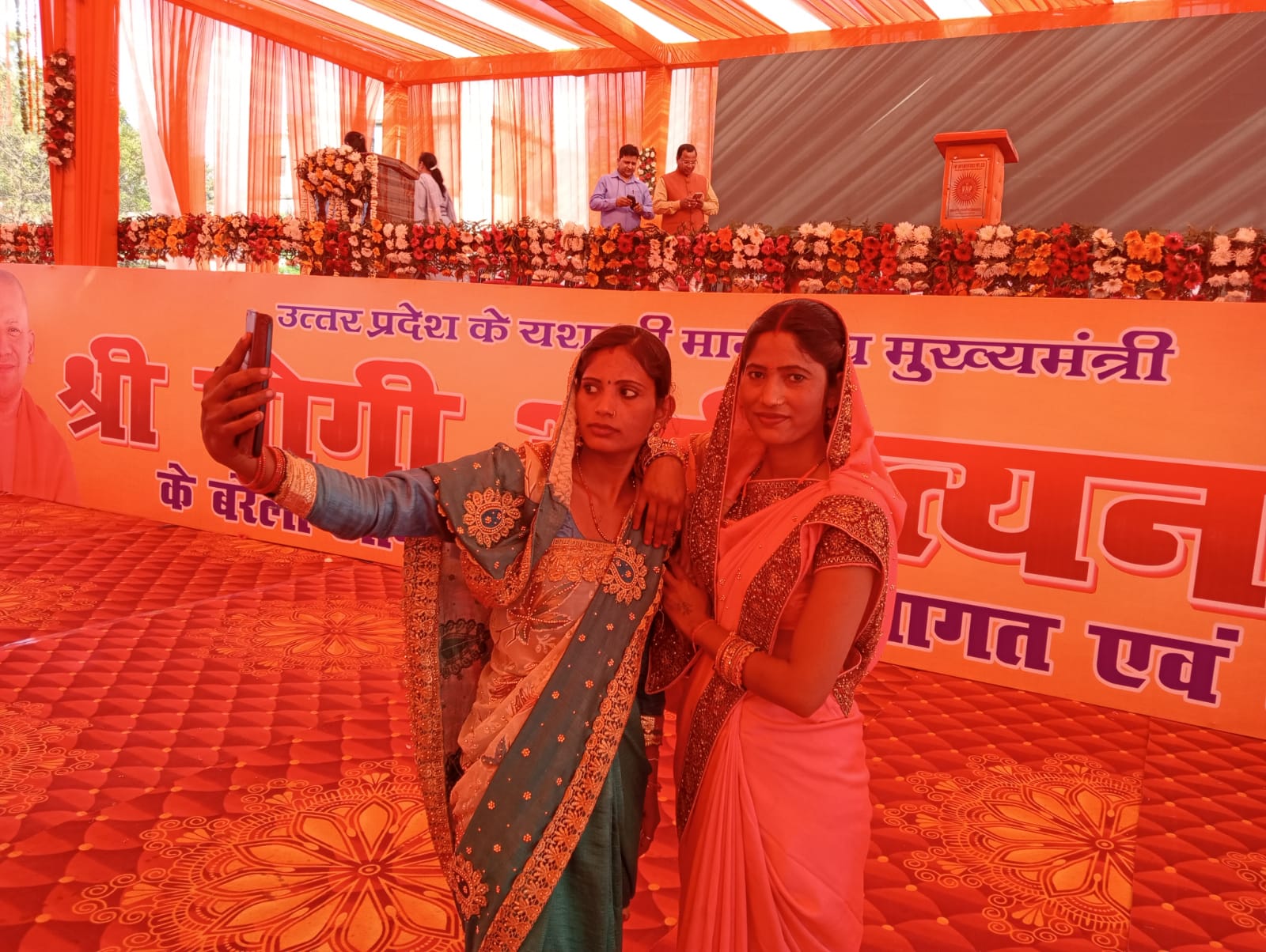 एक दूसरे के साथ सेल्फी लेतीं 2 महिलाएं।