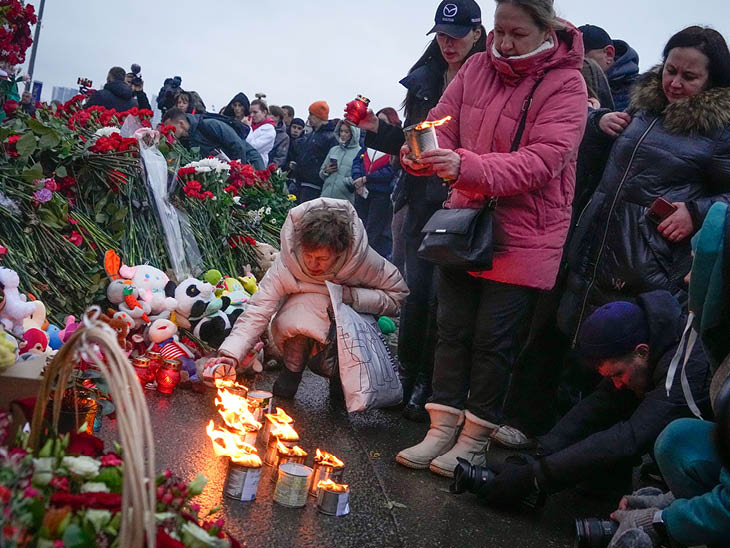 क्रोकस सिटी हॉल के पास लोग मोमबत्ती जलाकर और फूल रखकर हमले में मारे गए लोगों को श्रद्धांजलि दे रहे हैं।