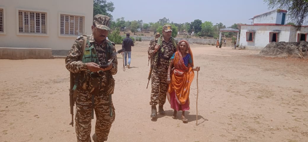 बांका के चांदन बूथ ओर 105 वर्ष की मनका देवी को वोटिंग बूथ तक ले जाते अर्धसैनिक बल के जवान।