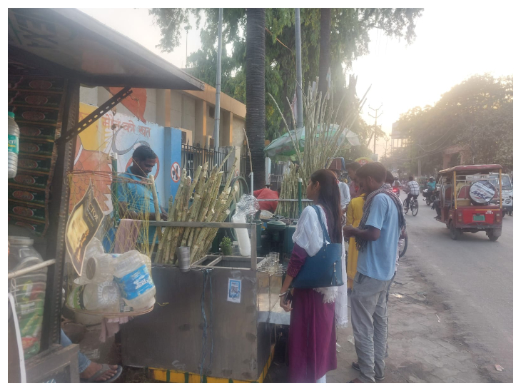 गर्मी की वजह से गन्ने का रस पीते लोग।